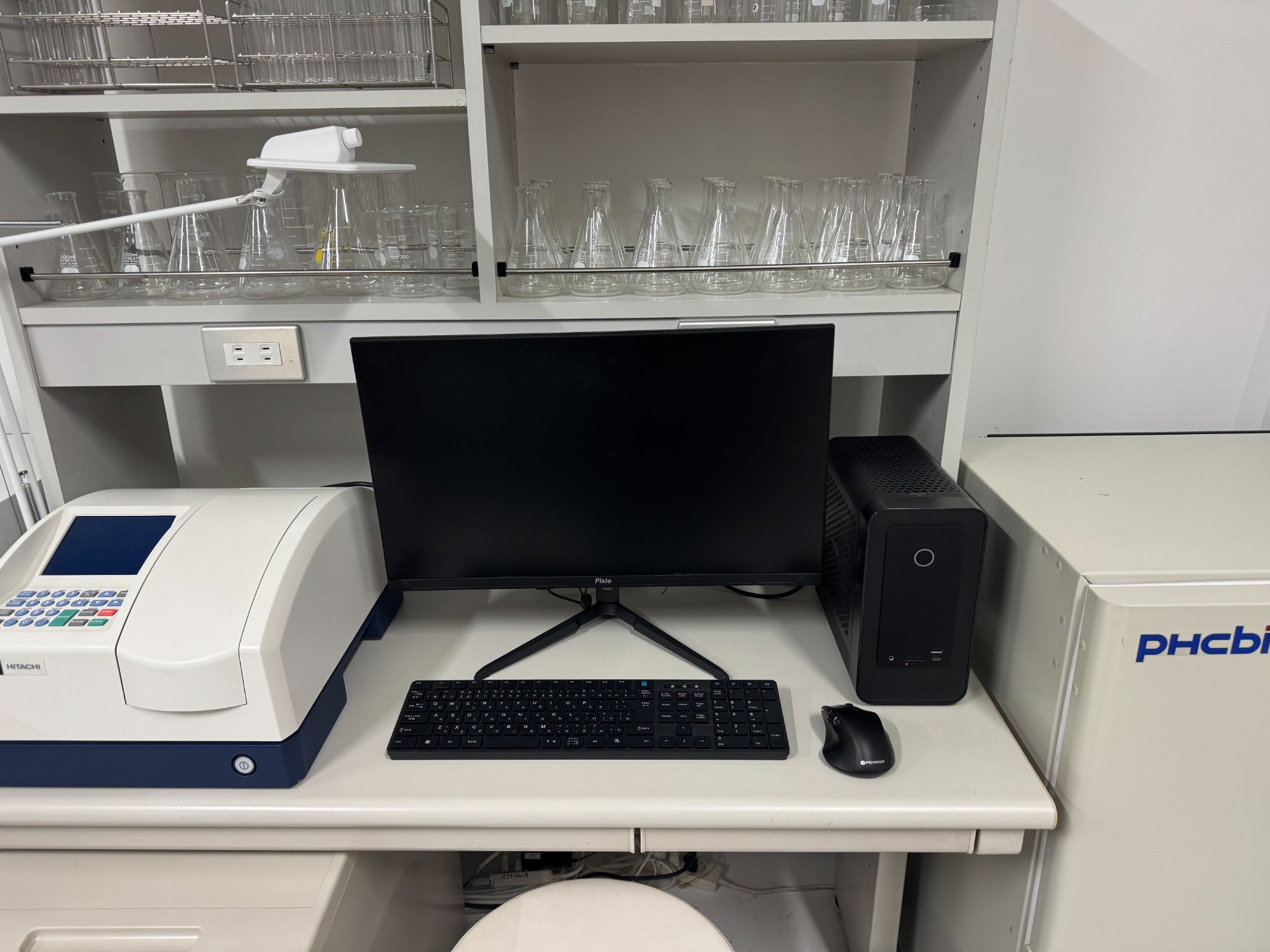 科捜研ラボのデスク正面。MAGNUS ONEがモニター横にコンパクトに収まっている。