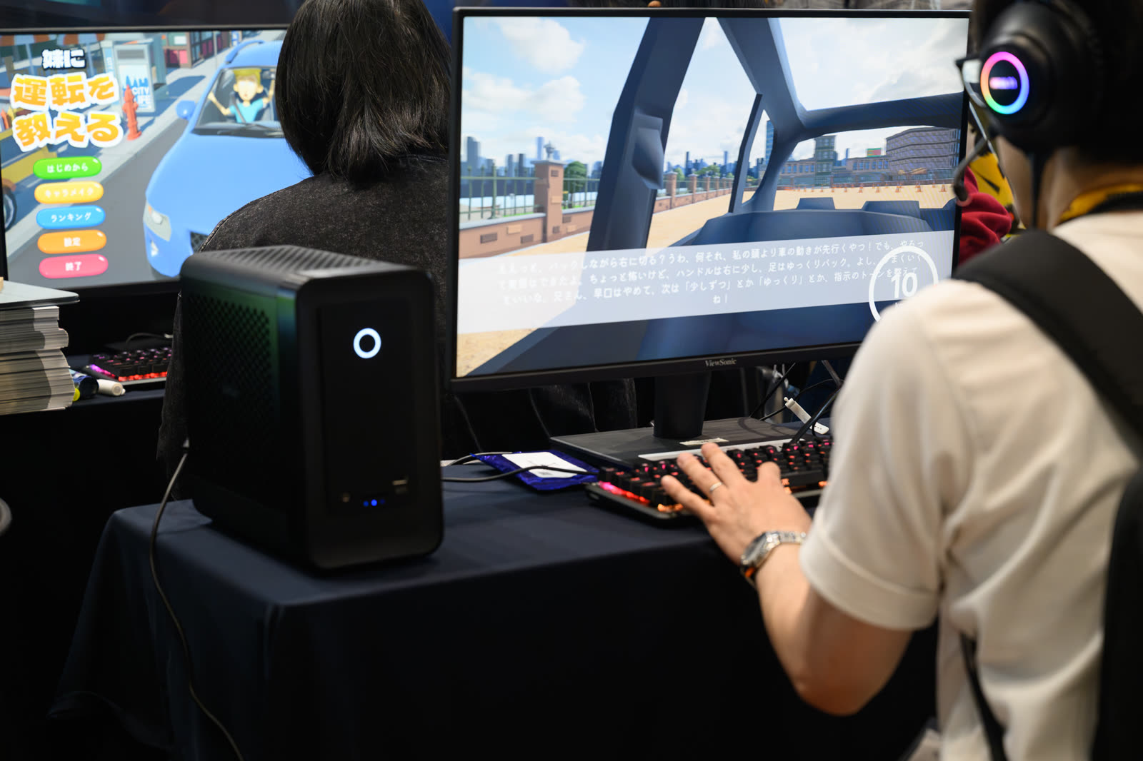 東京ゲームショウ2026 SELECTED INDIE 80 インディーゲーム試遊台 - モニターの横に設置された ZBOX MAGNUS ONE と試遊する来場者